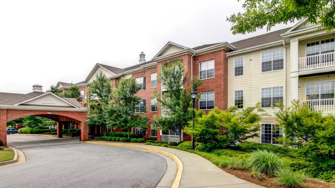 Building exterior of a senior living facility with gardens
