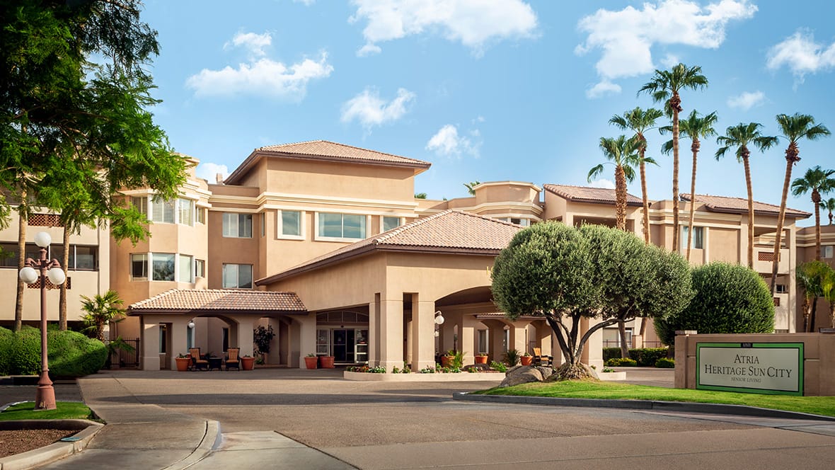 Exterior view of a senior living facility with palm trees
