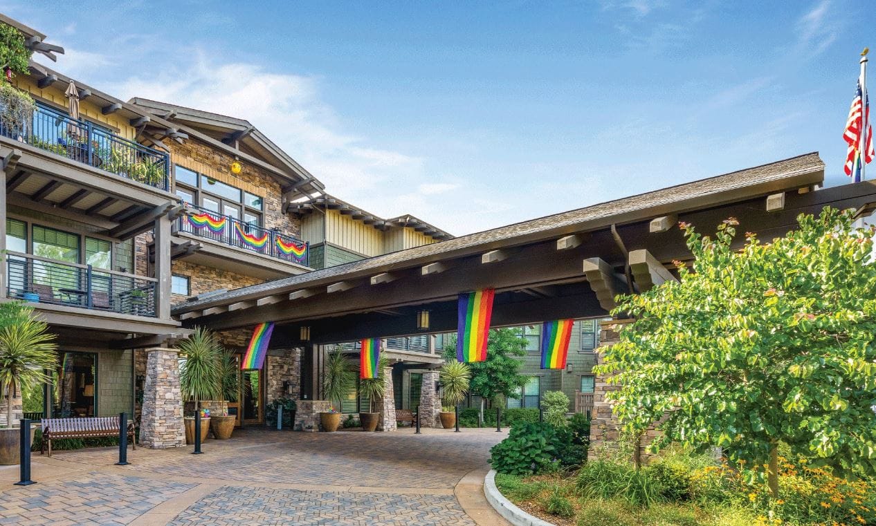 Exterior view of a senior living facility entrance with colorful flags