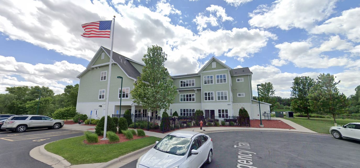 Exterior view of the assisted living facility with flag.