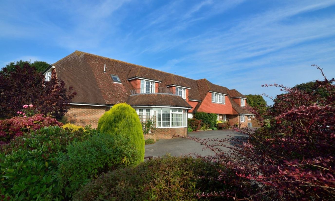Exterior view of Whitegates Care Home surrounded by landscaping
