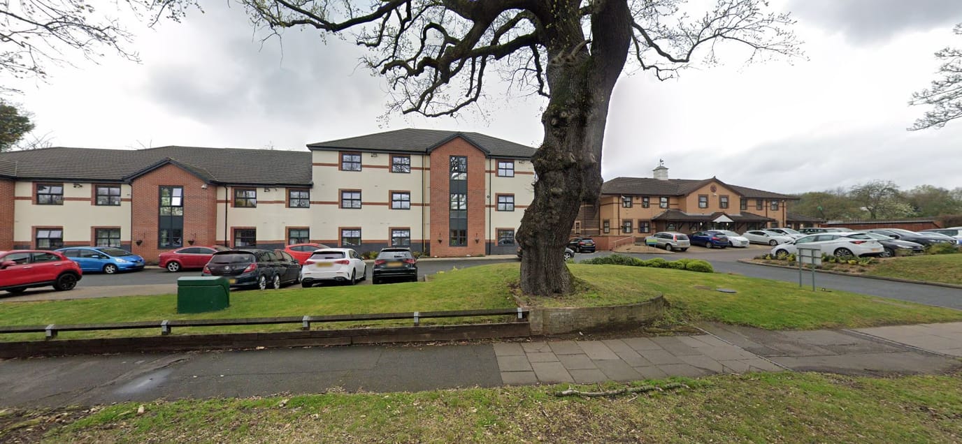 Exterior view of Willowbrook Care Home with parking lot