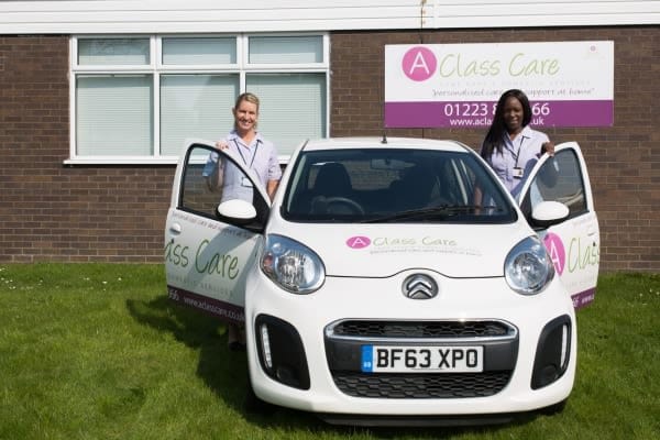 Staff members standing by the facility's vehicle