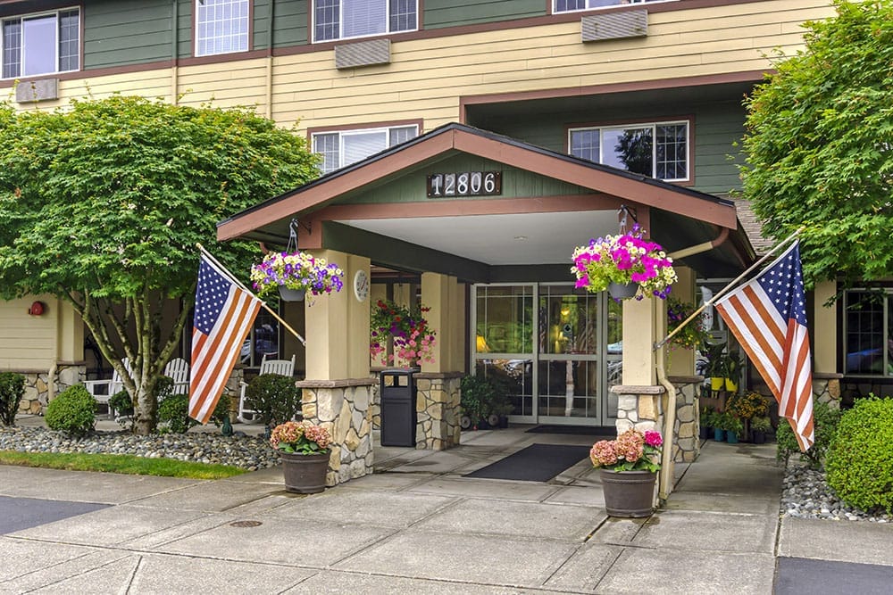 Exterior view of Brookdale Arbor Place entrance with American flags
