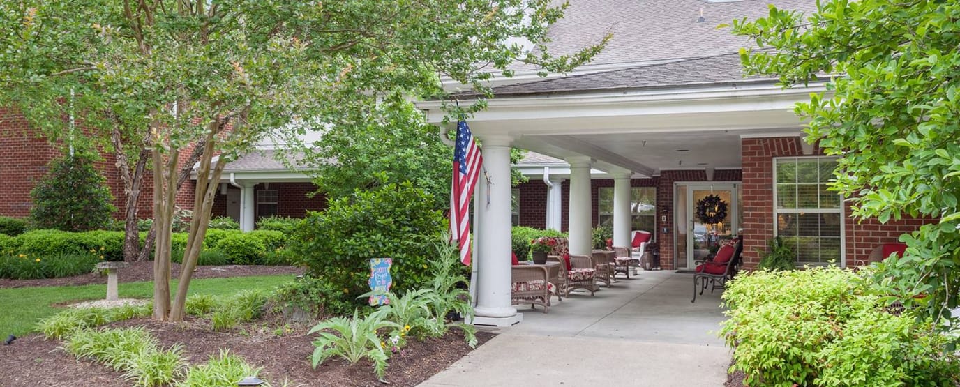 Covered entrance with seating and landscaping