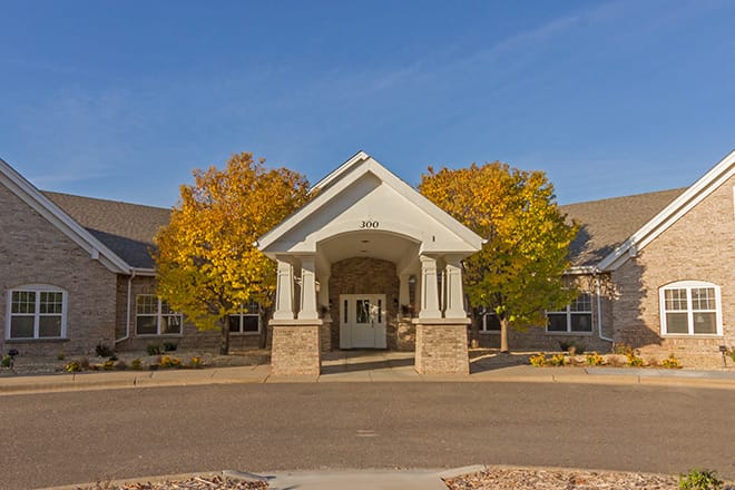 Front entrance of a senior living facility with trees
