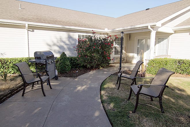 Outdoor seating area with grill and landscaping