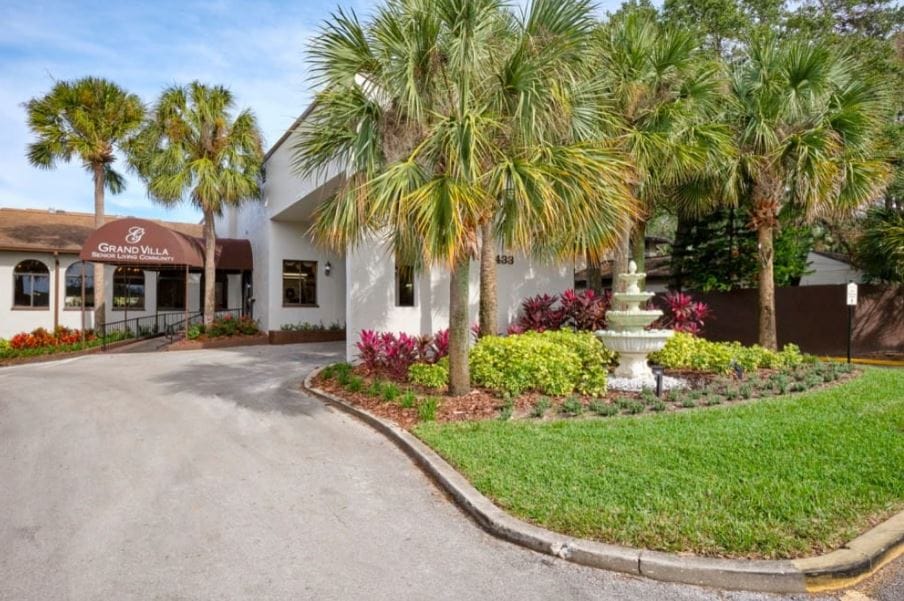 Exterior view of Grand Villa with palm trees and landscaped entrance