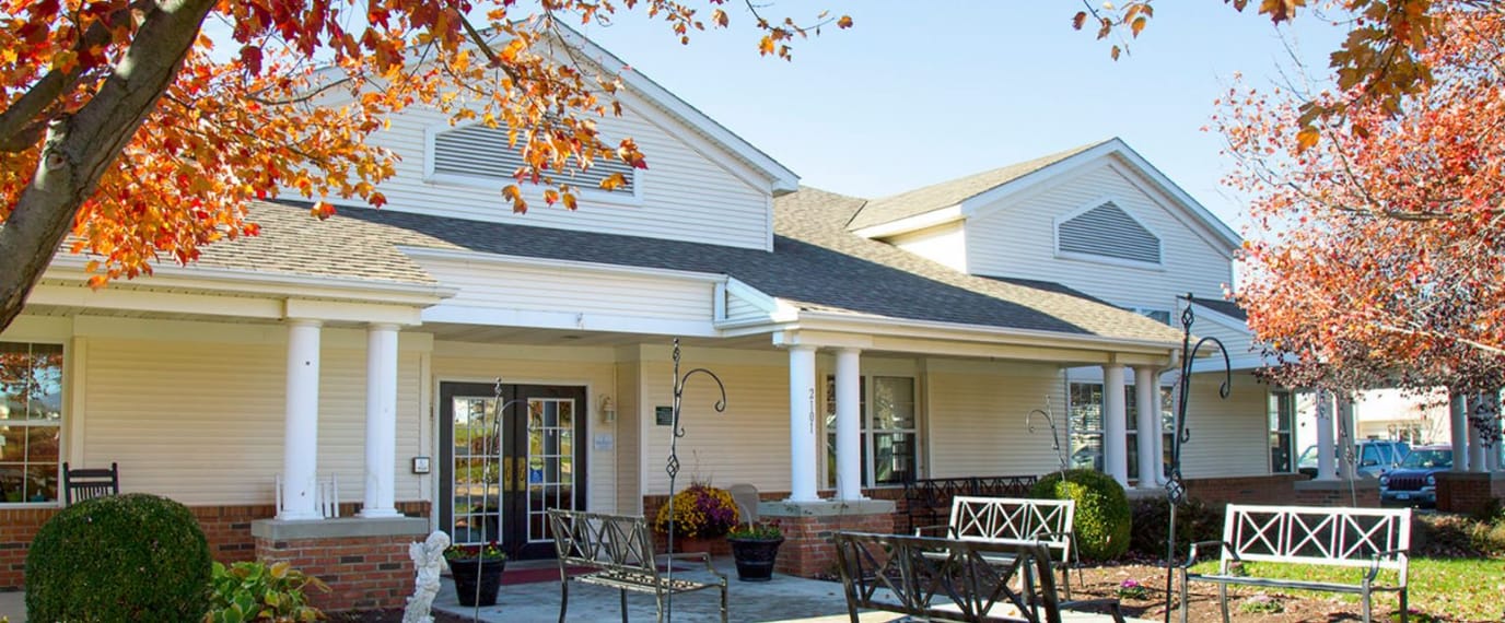 Exterior view of a senior living facility surrounded by fall foliage