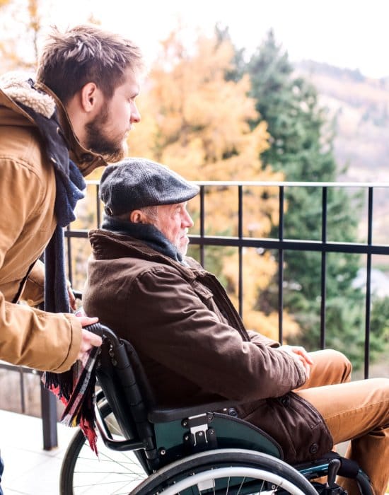Resident in a wheelchair enjoying the view with support