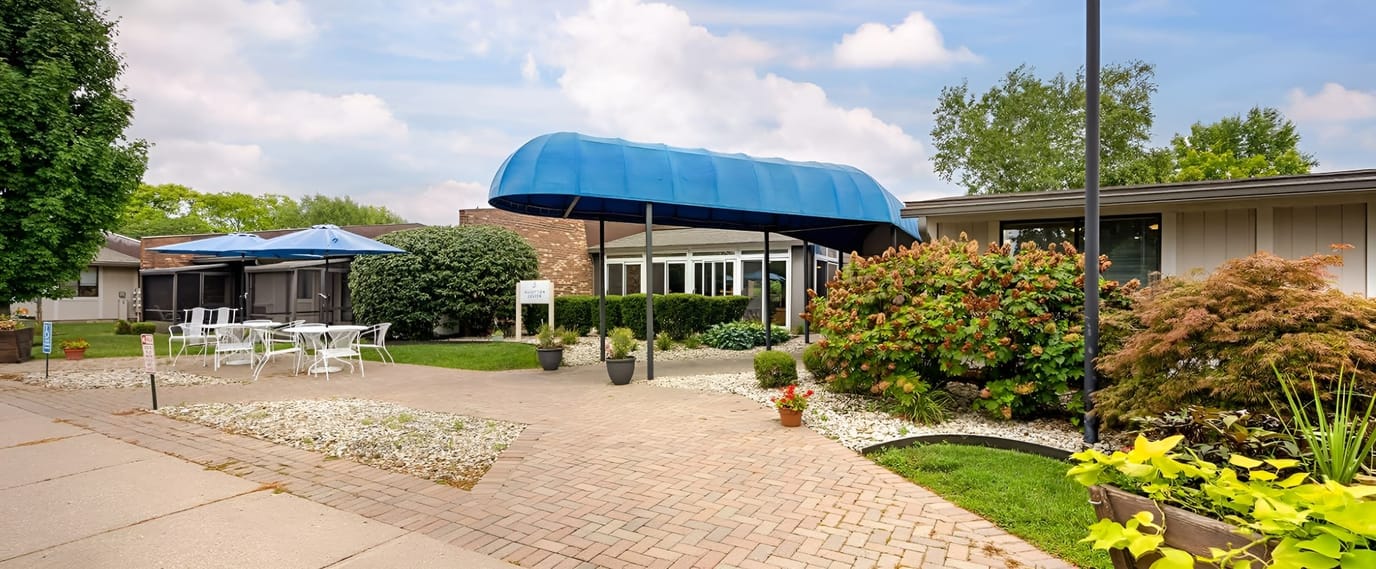 Front entrance of a senior living facility with outdoor seating