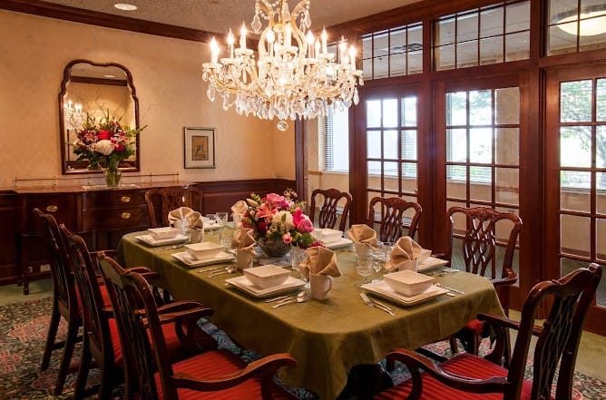 Elegantly set dining room with a chandelier and floral centerpiece