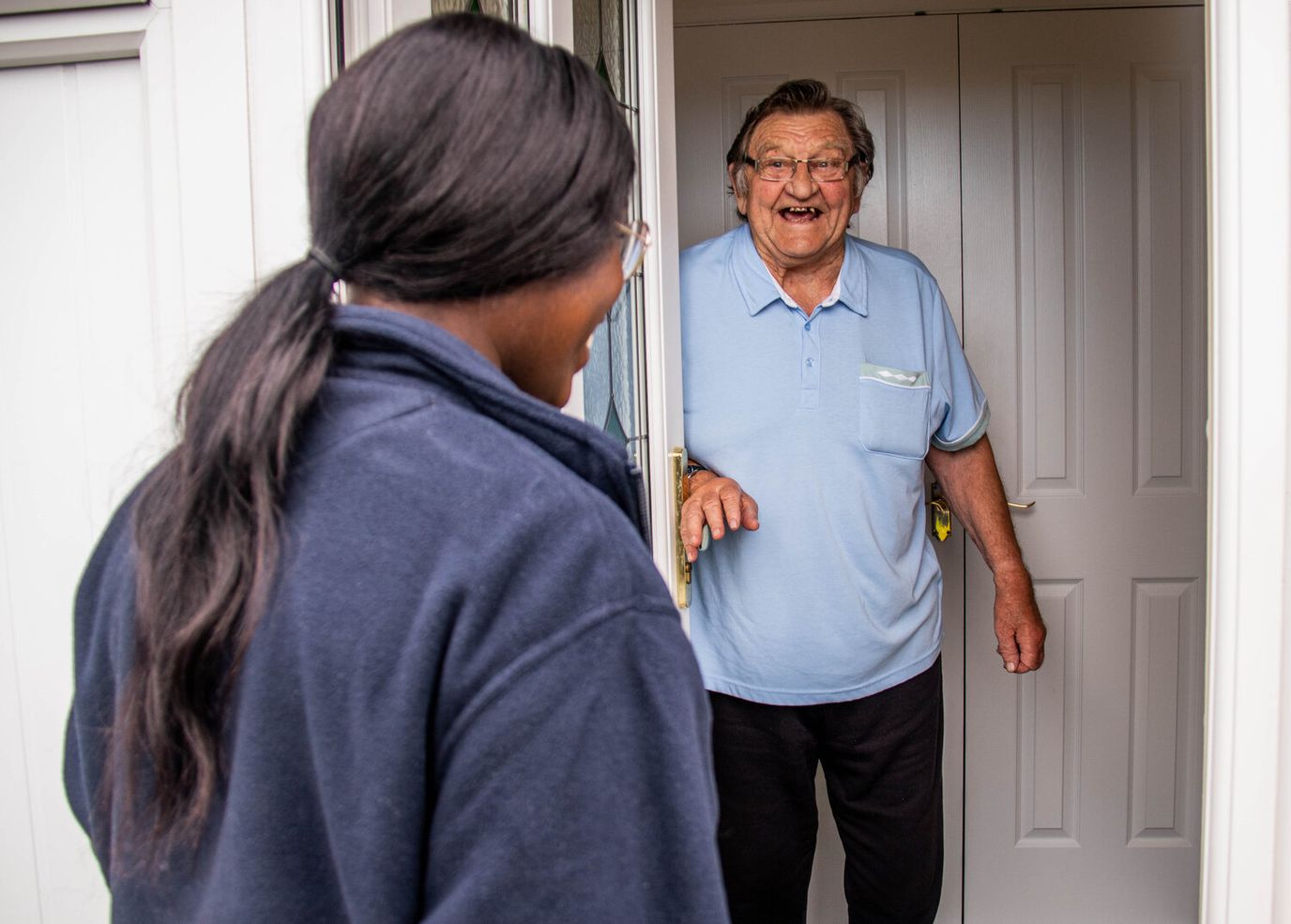 Senior man greeting a visitor at the door