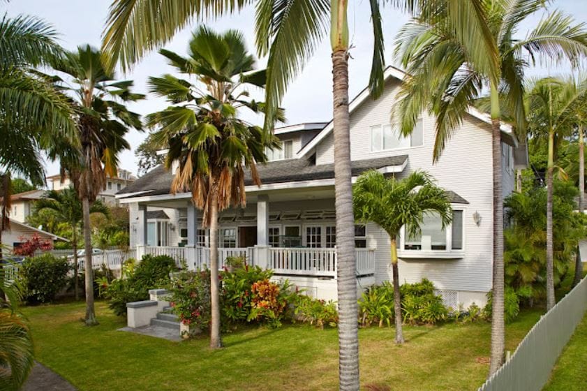 Exterior view of a senior care facility surrounded by palm trees