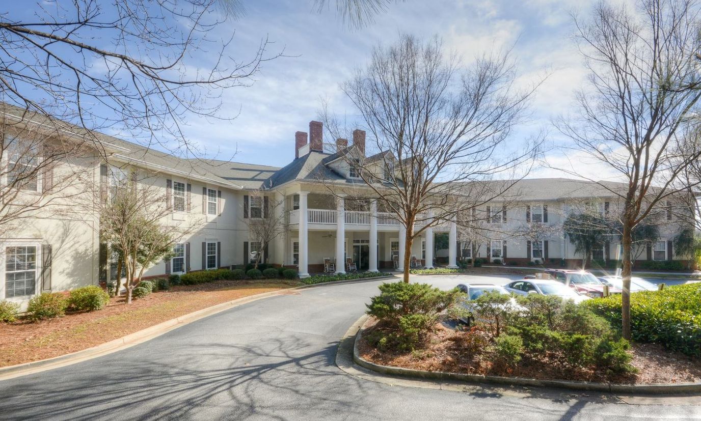 Exterior view of Oaks at Stockbridge with trees and parking
