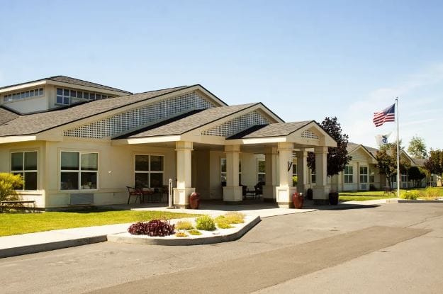 Exterior view of Settler's Park Senior Living with American flag
