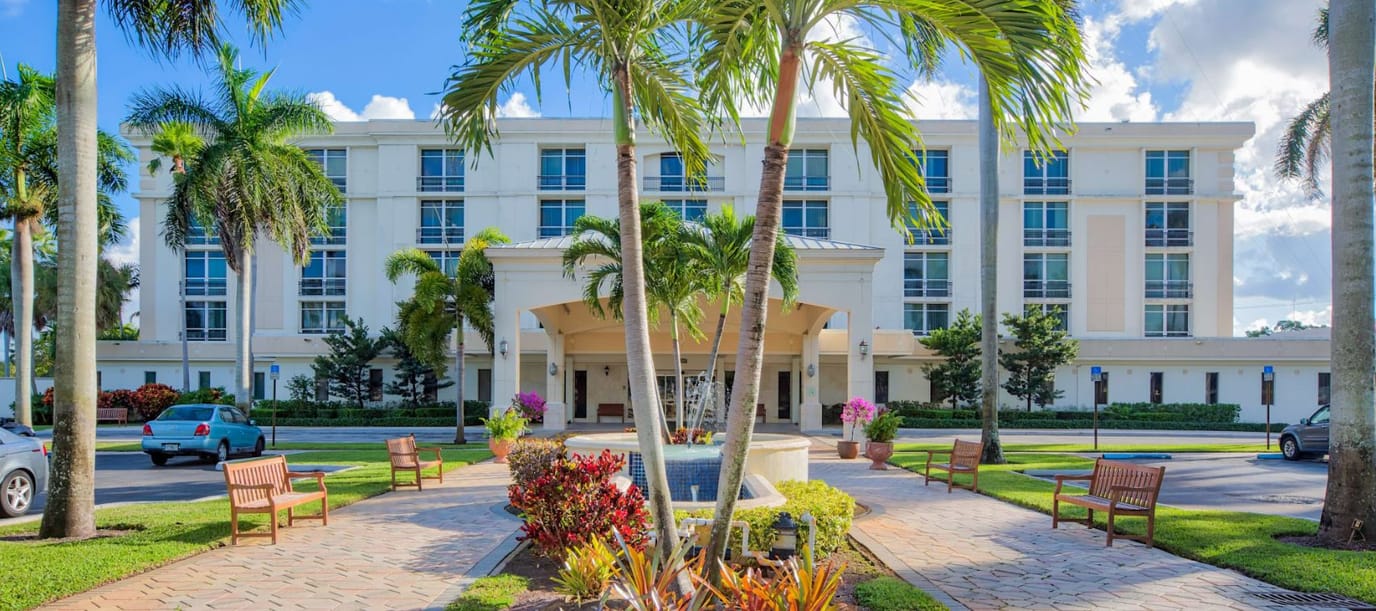 Exterior view of the assisted living facility with gardens and seating
