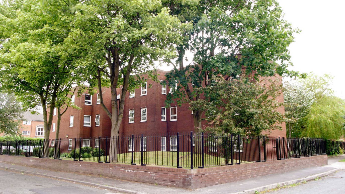 Exterior view of a senior living facility surrounded by trees