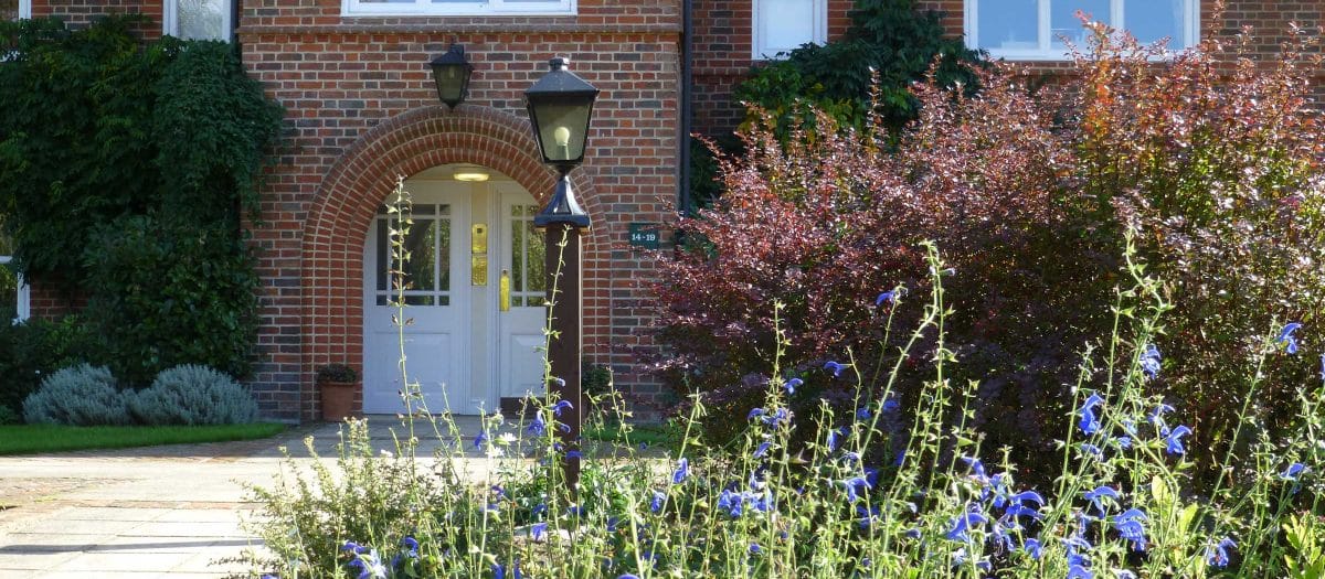 Building entrance with flower beds and lamppost
