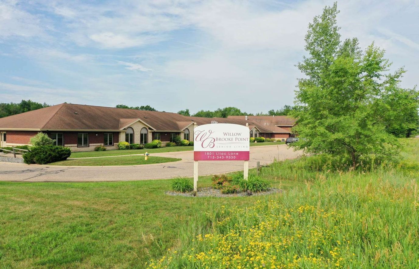 Exterior view of Willow Brooke facility with sign and landscaping