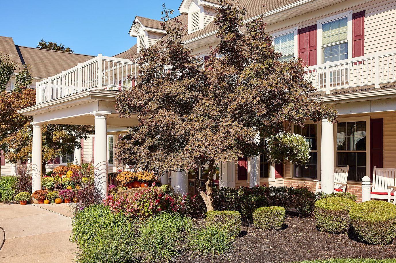 Exterior view of a senior living facility with gardens.