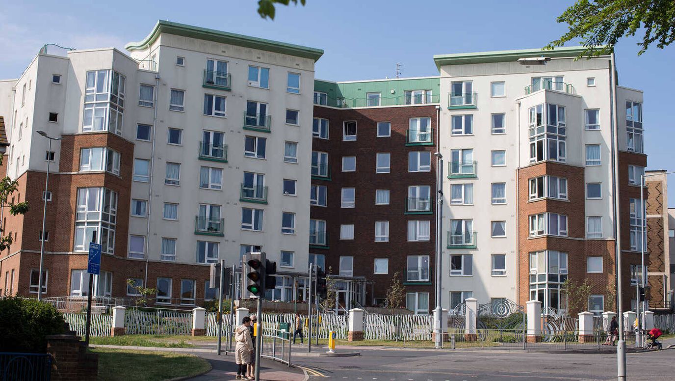 Exterior view of a senior living facility with residents outside