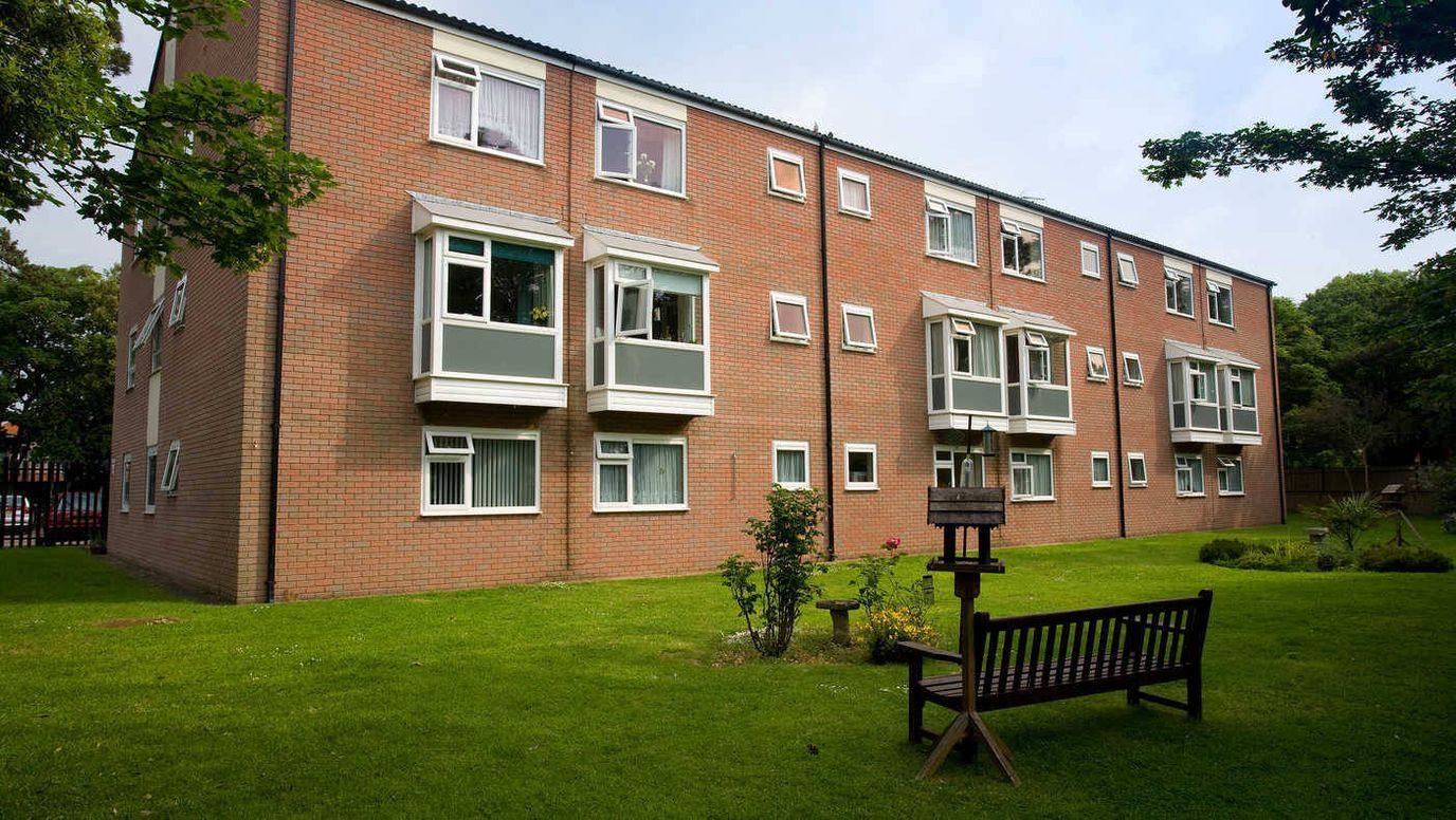 Exterior view of a senior living facility with gardens