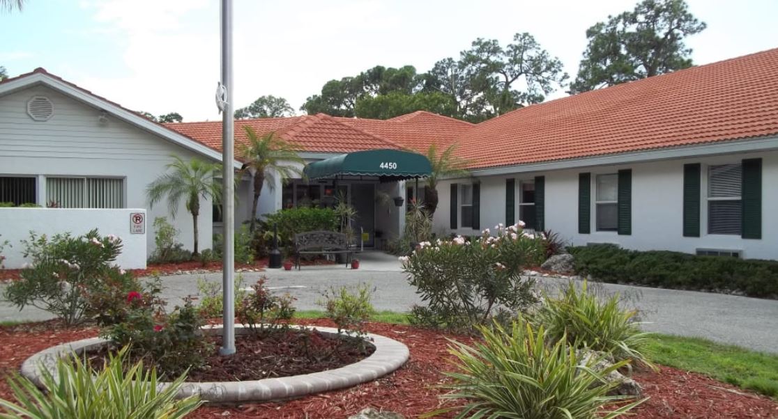 Exterior view of assisted living facility entrance and gardens