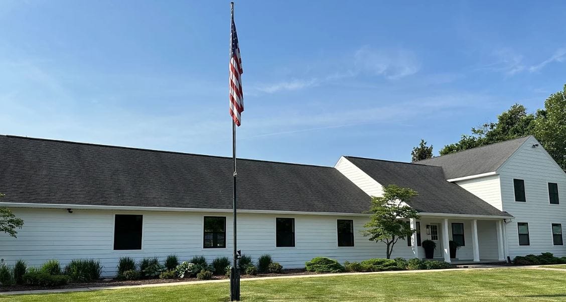 Exterior view of a facility building with flag