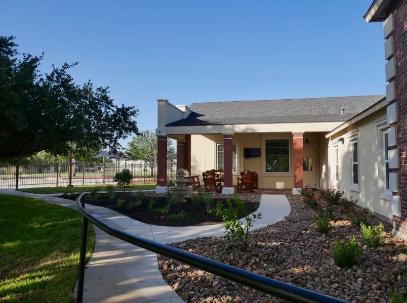 Exterior view of an assisted living facility with garden