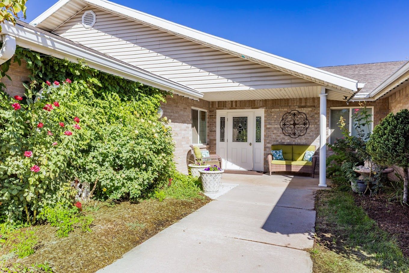 Entrance to an assisted living facility surrounded by greenery