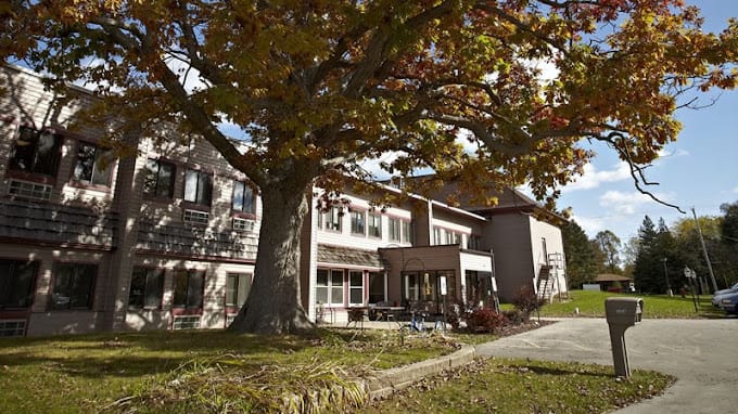 Exterior view of a senior living facility with autumn foliage