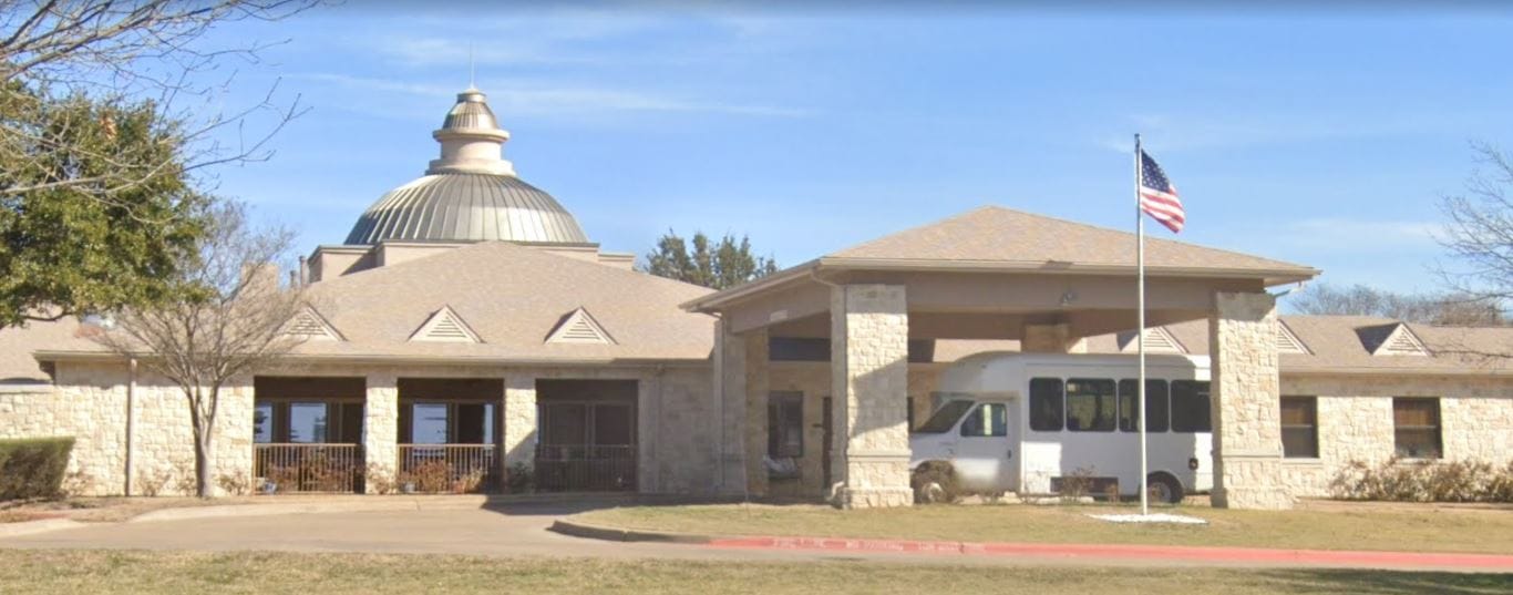 Front entrance of the Courtyards at Lake Granbury with a shuttle bus