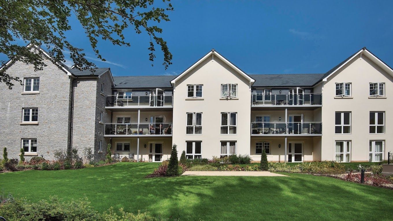 Exterior view of Fitzford Lodge with green lawn and balconies