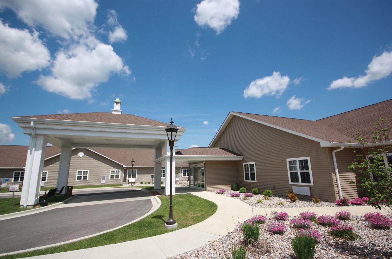 Exterior view of a senior living facility surrounded by gardens