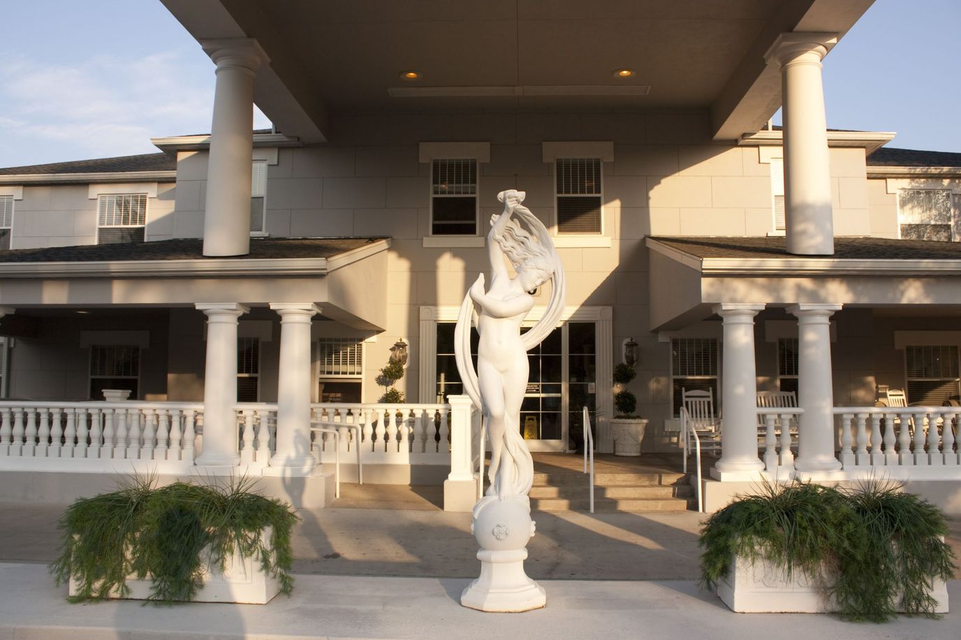 Front entrance of a senior living facility with a statue
