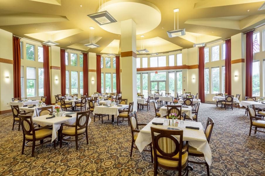 Bright dining room with tables set for residents