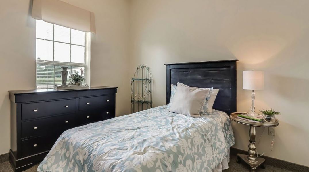 Cozy private resident room with a bed and dresser