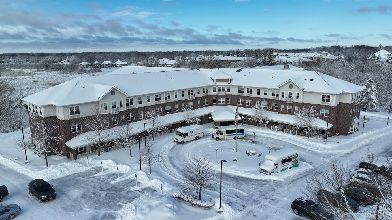 Aerial view of a snow-covered nursing home with vehicles