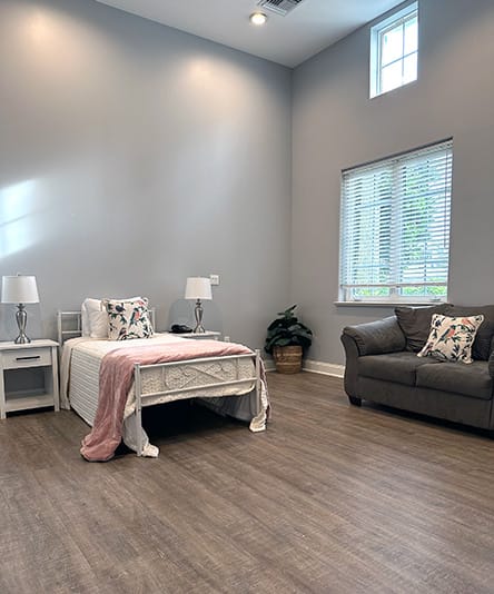Cozy and bright resident room with a bed and sofa