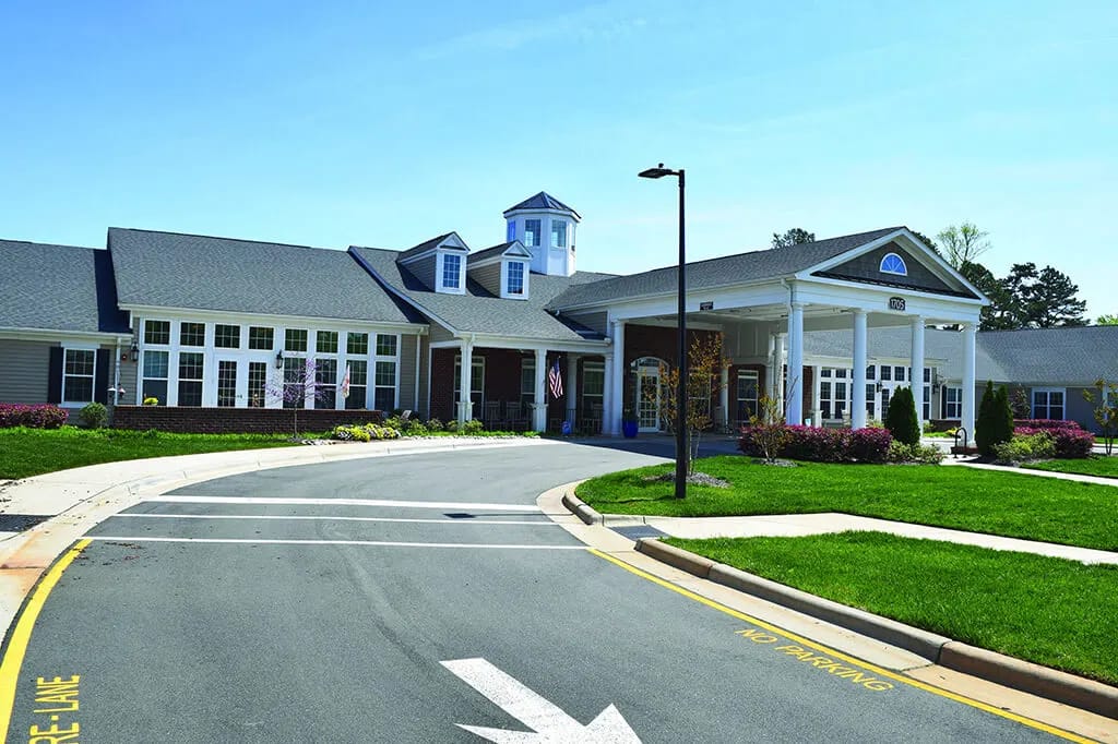 Front exterior of a senior living facility with landscaping