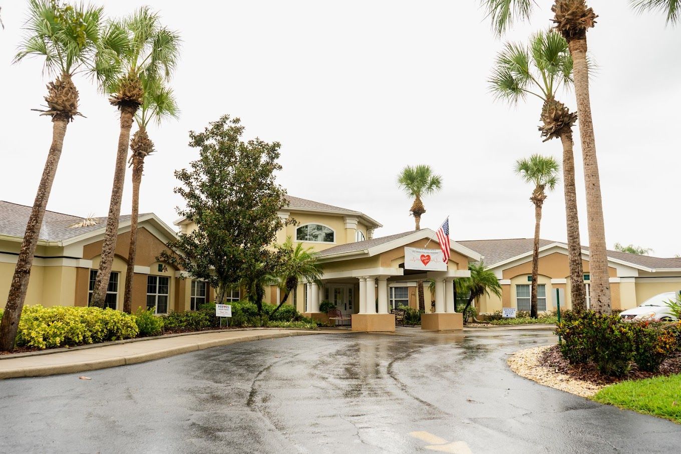 Exterior view of a senior living facility surrounded by palm trees