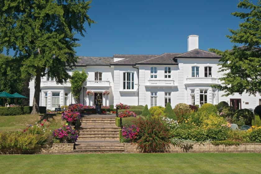 Exterior view of a senior living facility with gardens and landscaping
