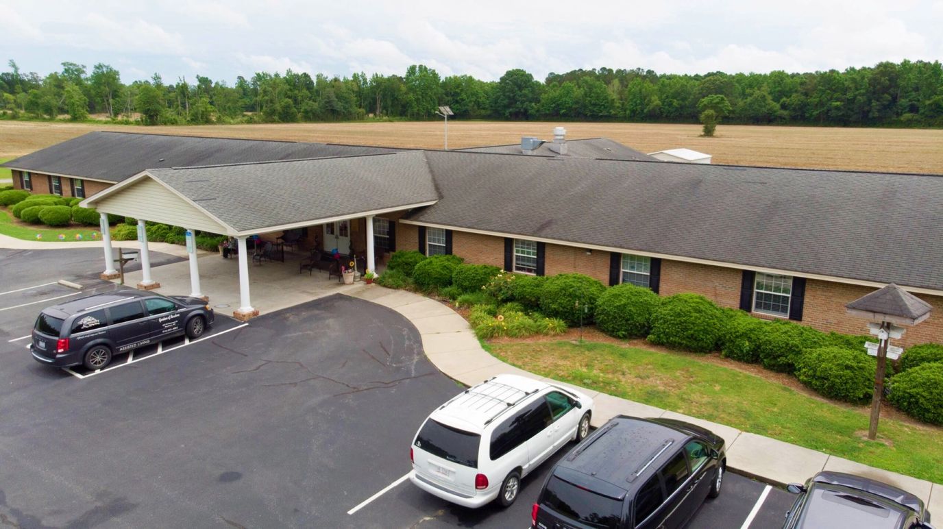 Drone view of a senior care facility with gardens and parking