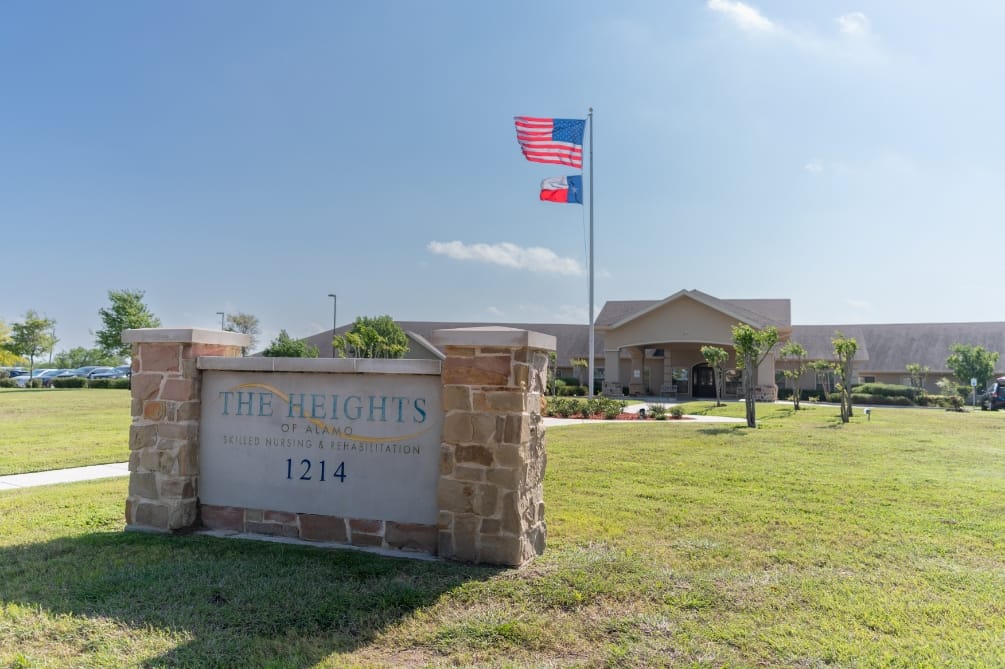 Exterior view of The Heights of Alamo building with flags