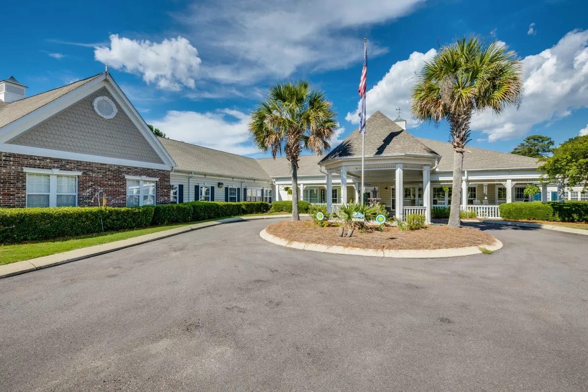 Exterior view of assisted living facility with palm trees
