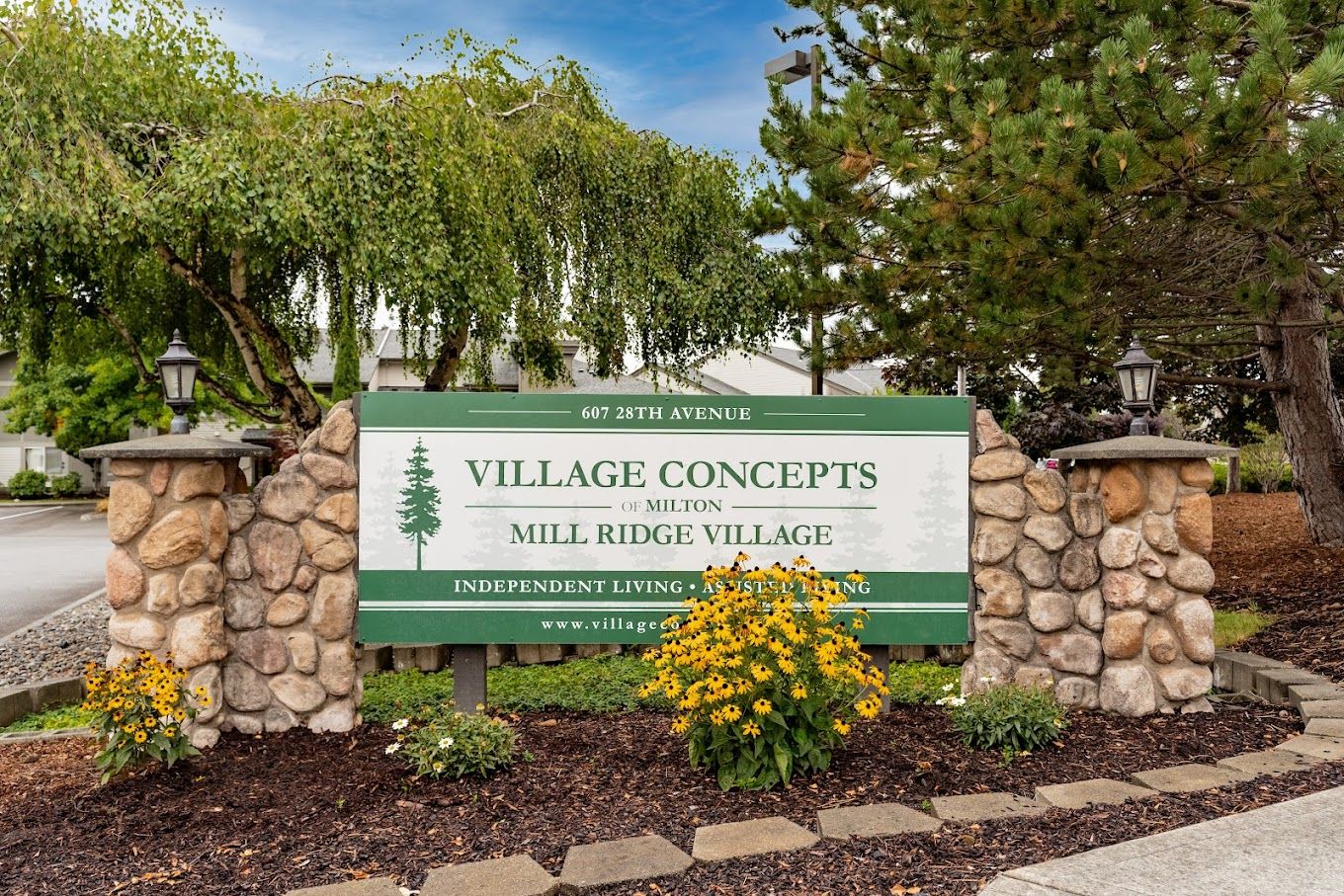 Sign for Village Concepts of Milton with flowers