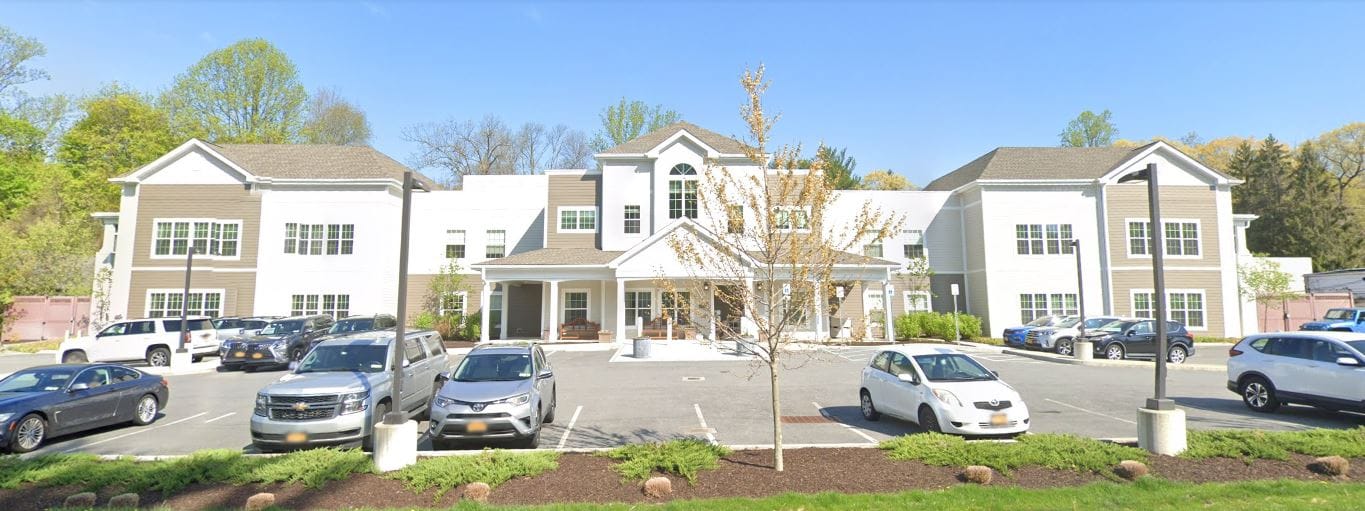 Exterior view of Artis Senior Living facility with parking