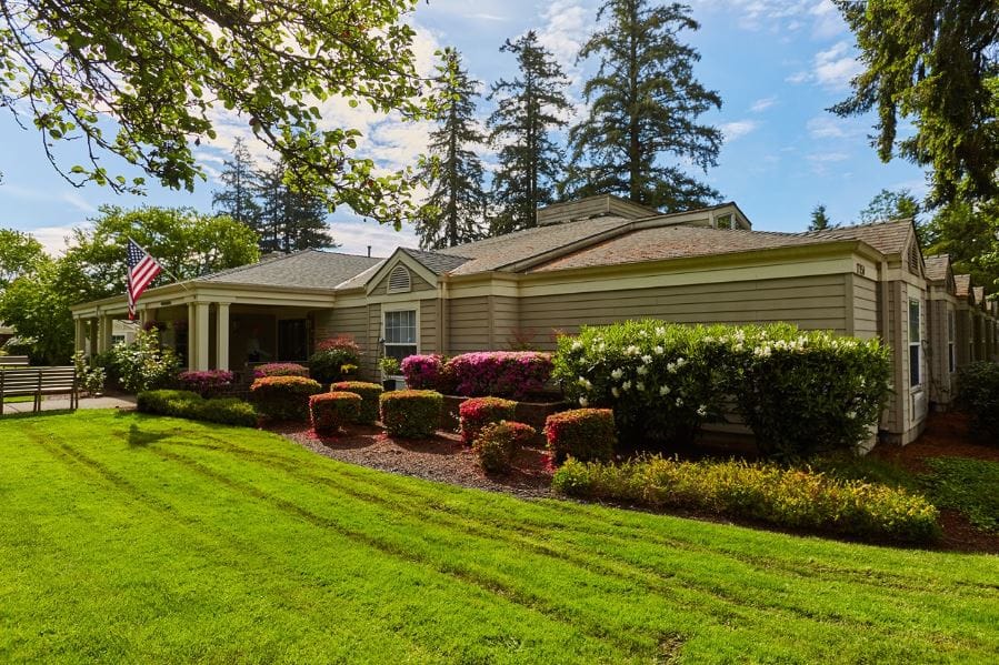 Exterior view of a senior living facility with gardens