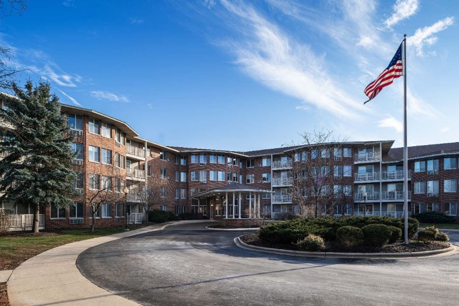 Exterior view of Library Square Senior Living with flag